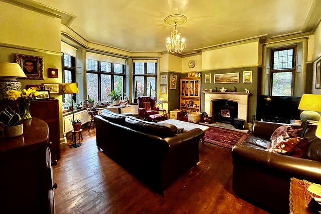 This sitting room with large bay window and southerly views, has a stone fireplace with an open grate for real fires.