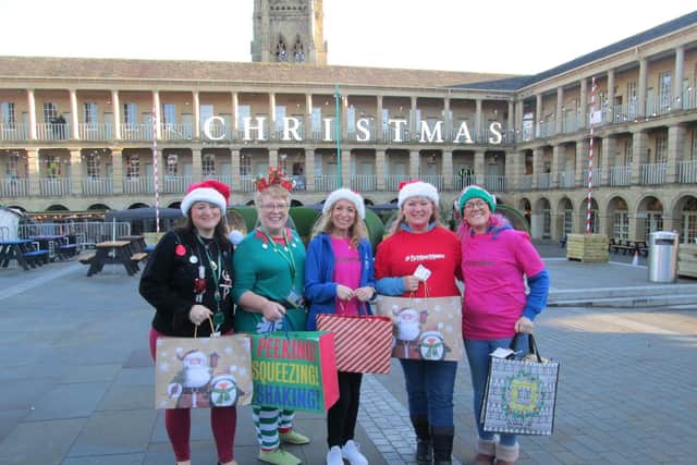 Focus4Hope and Calderdale Lighthouse wrapping donated Christmas gifts in The Piece Hall last Christmas