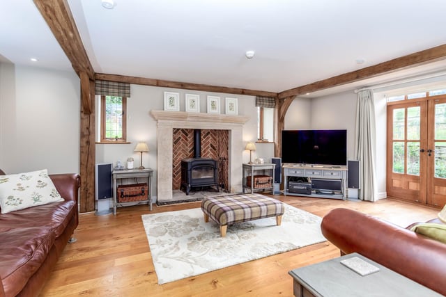 The living room has a feature fireplace of herringbone brick design, containing a woodburning stove.