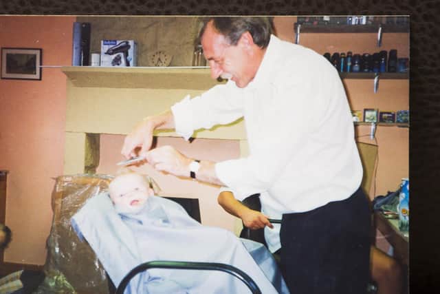 Barber David Adams cutting one of his grandson's hair