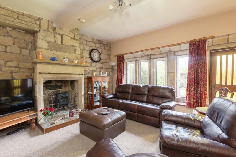 This sitting room has a lovely stone fireplace, with exposed stonework to the wall and a beamed ceiling.