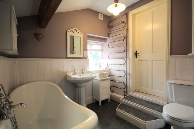 This stylish bathroom includes a free standing bath and a towel radiator fashioned from copper piping.