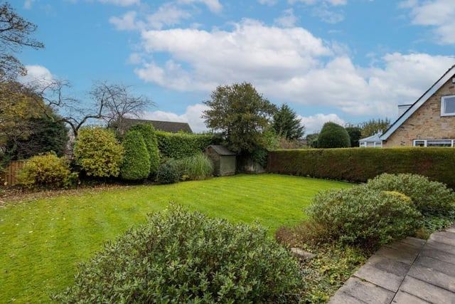 Mature shrubs, trees and hedging surrounds the lawned garden.