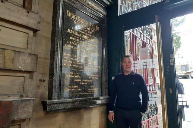 Sean Sutcliffe, President of the Halifax Borough Market Traders' Association and from Toffee Smith's sweet stall, with the plaque commemorating the opening of Halifax Borough Market