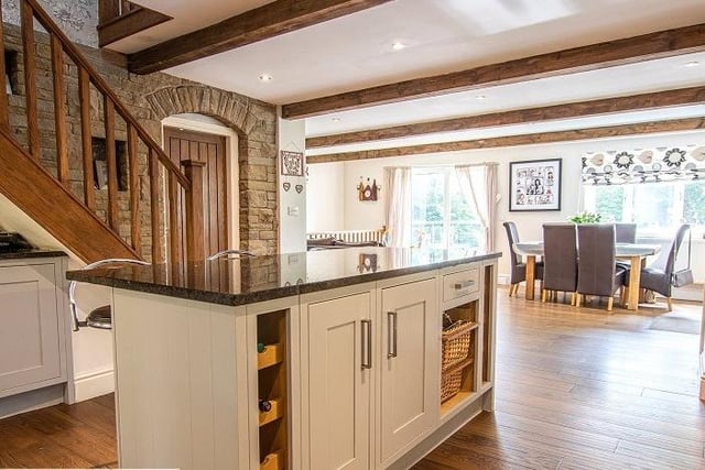 A fitted kitchen with work island and breakfast bar opens through to the dining area.