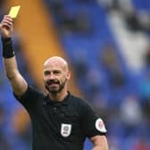A referee shows a yellow card
