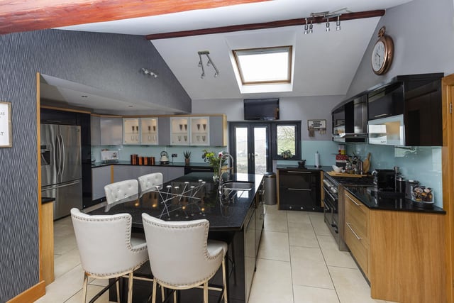 The super high-spec kitchen includes a large island unit with breakfast bar.