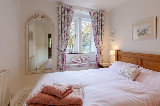 A pretty bedroom with an inbuilt window seat, from which to admire the scenery outside.