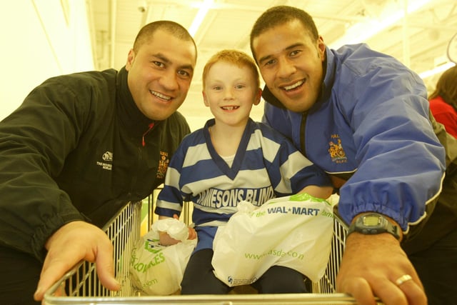Halifax RLFC stars Martin Moana,L, and Anthony Seuseu help eight-year-old Billy Lacey bag pack with Siddal U8s