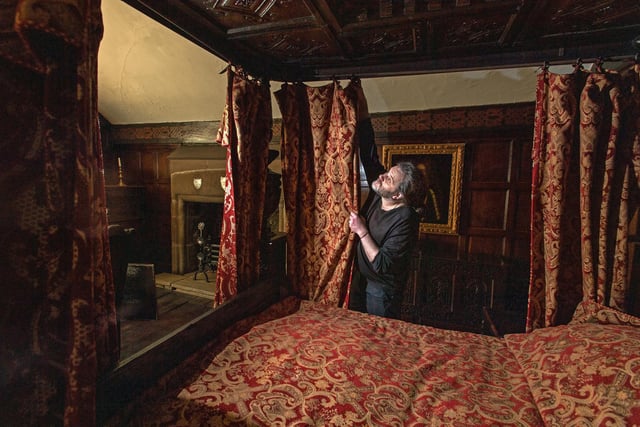 Chris Southwell making the bed in the red bedroom at Shibden Hall