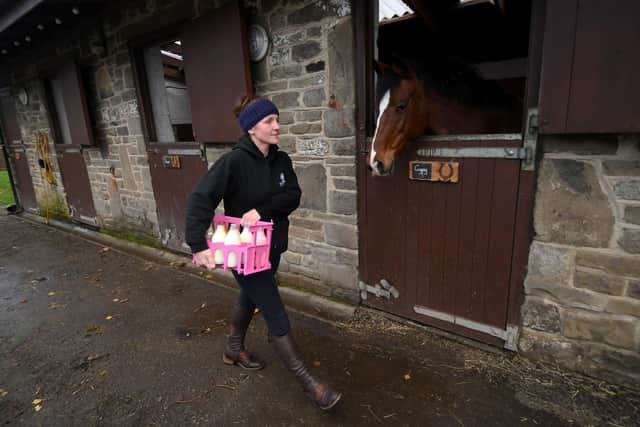 Debbie Ogden pictured carrying a crate of milk at Gardens Farm Greetland.