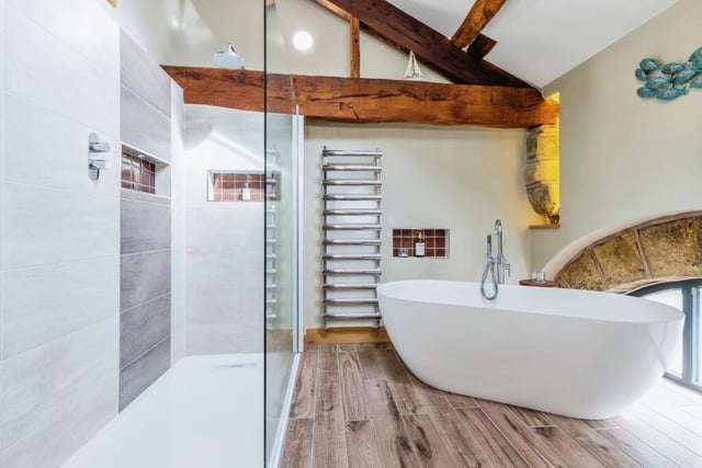 An en suite bathroom with a free-standing bath and walk-in shower unit.
