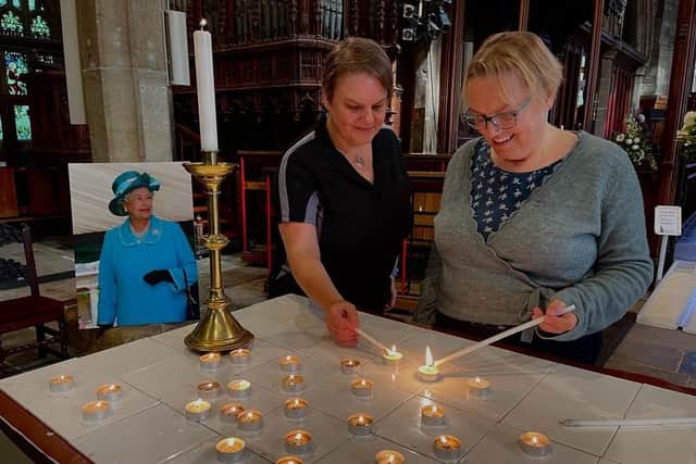 Councillor Ann Kingstone and her sister Marie Wright lighting candles at Halifax Minster