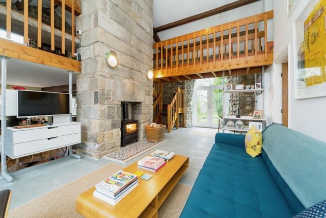 A stone chimney feature houses a multi-fuel stove in the open plan interior of the property.