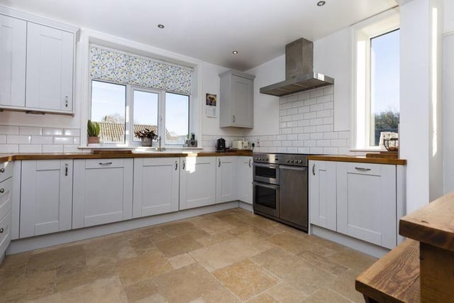 The kitchen has shaker-style units with solid timber worktops.
