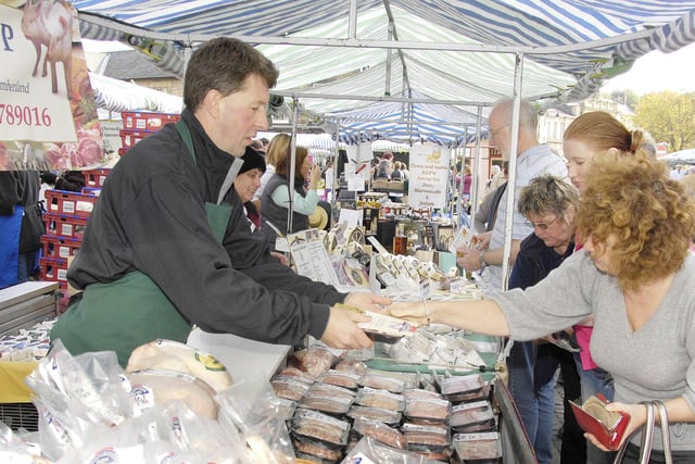 A stallholder does a brisk trade in meat and poultry.