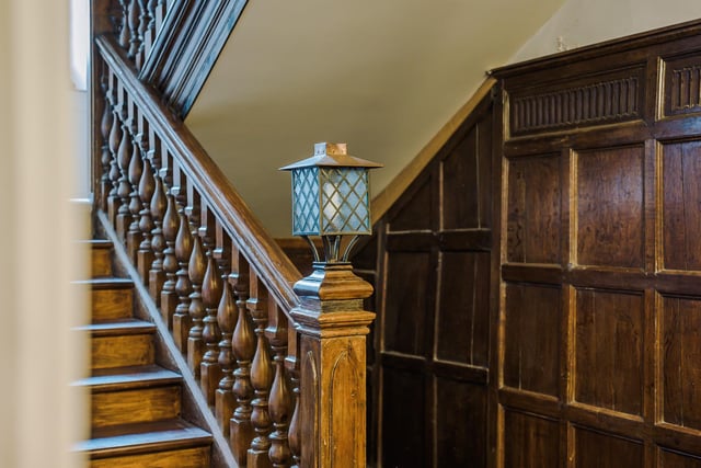 Wood panelling with the grand oak staircase that leads to a half-landing, then the first and second floor.