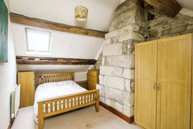 This beamed bedroom is one of four within the property.
