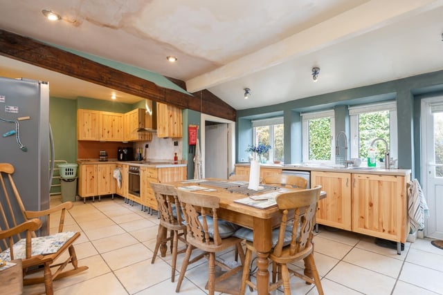 Spacious kitchen with large dining space fitted with a range of wall and base units with complementary work tops and an external door leading to the garden.