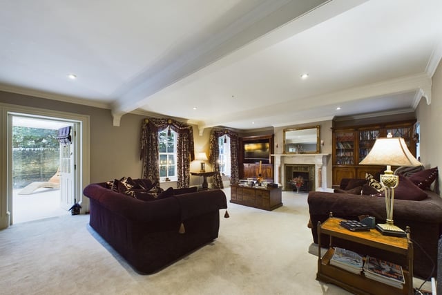 A spacious reception room with feature fireplace and doors leading outside.