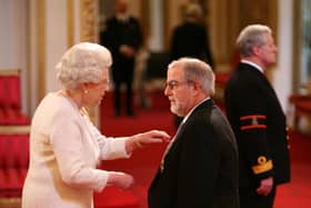 Roger Harvey receiving his OBE from The Queen