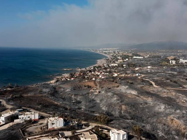 An aerial view shows smoke billowing in background of Kiotari village, on the island of Rhodes. Tens of thousands of people have already fled blazes on the island of Rhodes, with many frightened tourists scrambling to get home.