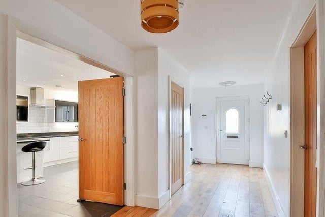 A welcoming hallway with oak floor and oak-faced doors to the ground floor rooms.