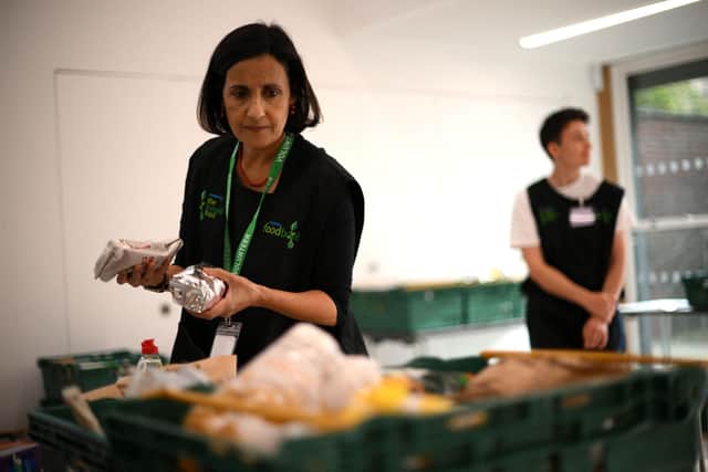 A member of staff sorts through food items inside a food bank in the UK. (Photo by DANIEL Leal/AFP via Getty Images)