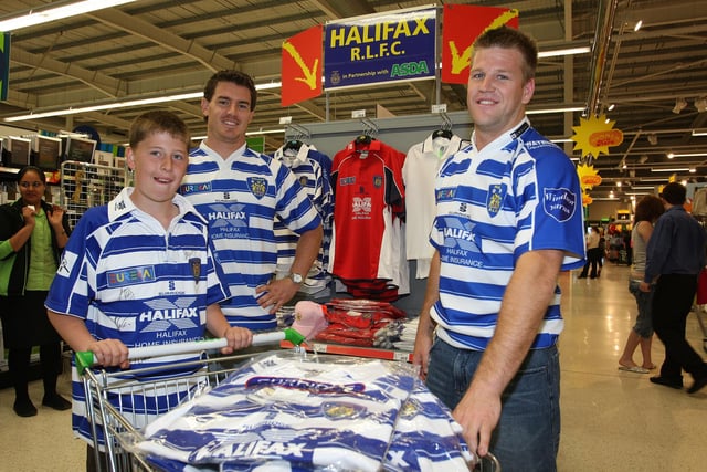 Halifax Rugby League players Shad Royston and Ben Black with fan Matthew Berry, aged 11, at the new Halifax Rugby League stand in ASDA Halifax