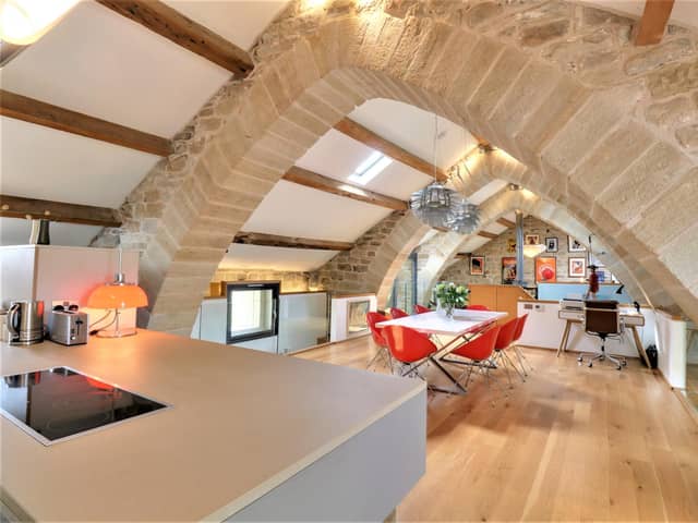 This unique home has stone arches to divide its open plan 'heart' in to living sections.