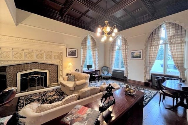 The lounge is packed with original features, from the coffered ceiling, to arched gothic windows, and feature fireplace.