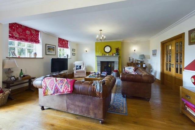 The spacious lounge, with a solid oak floor, and feature fireplace.