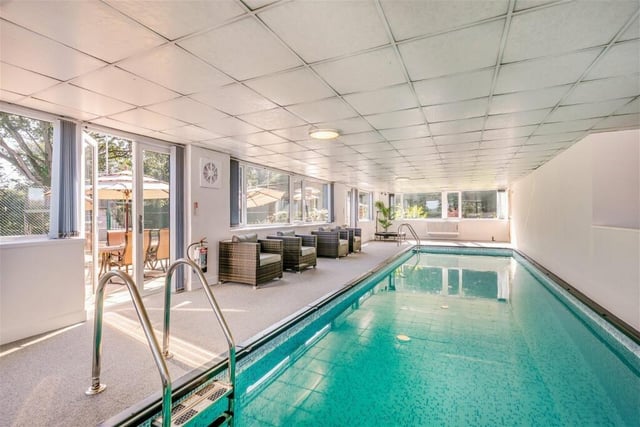 The indoor swimming pool has doors leading out to a patio terrace.
