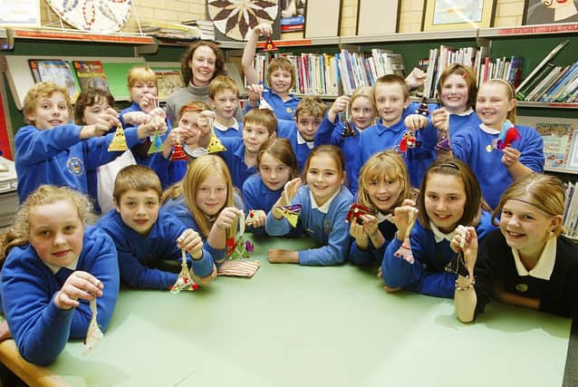 Amy Leader from Ribbon Circus with children and the Christmas tree decorations they have made in Art Club at Luddenden Dene Primary School