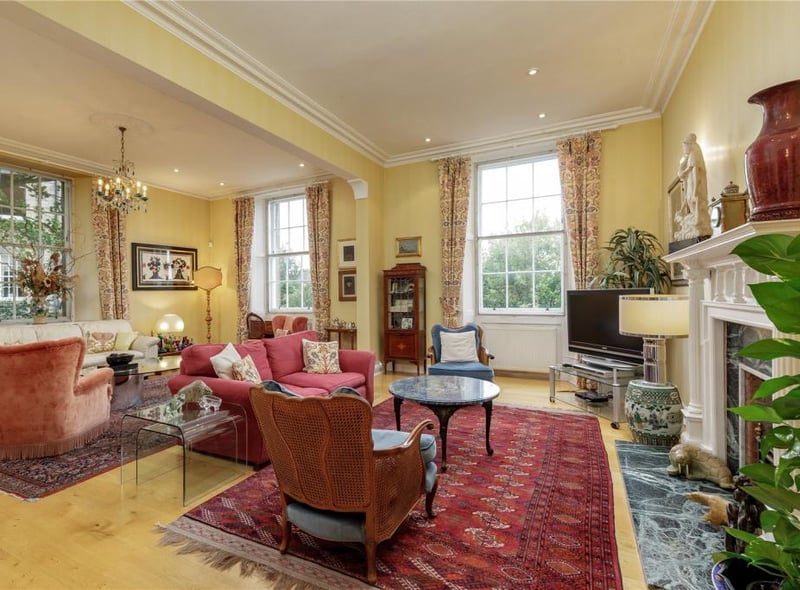 The drawing room has three sash and case windows, a feature fireplace, and detailed cornicing.