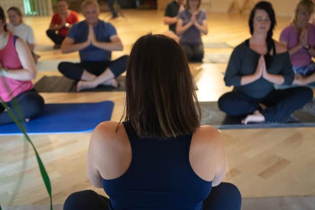 Yoga teacher, Adele Wills, leads an indoor yoga class