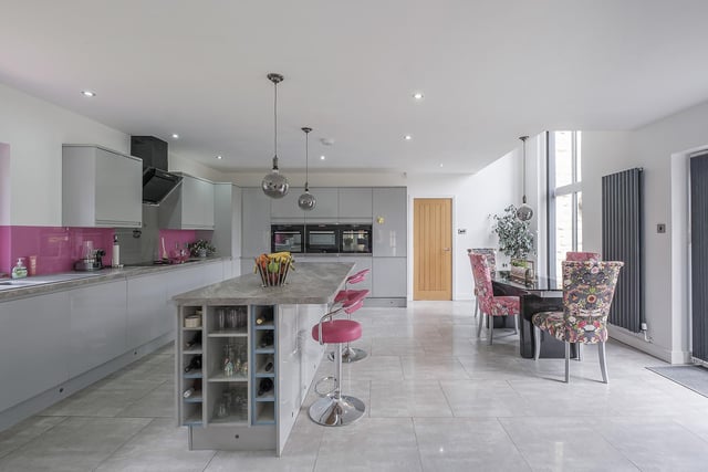 The stylish, open plan kitchen has a central island with breakfast bar.