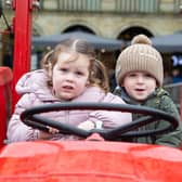 Isla Flowett and Teddy Howson enjoying tractors and farm vehicles in the courtyard at The Piece Hall, Halifax