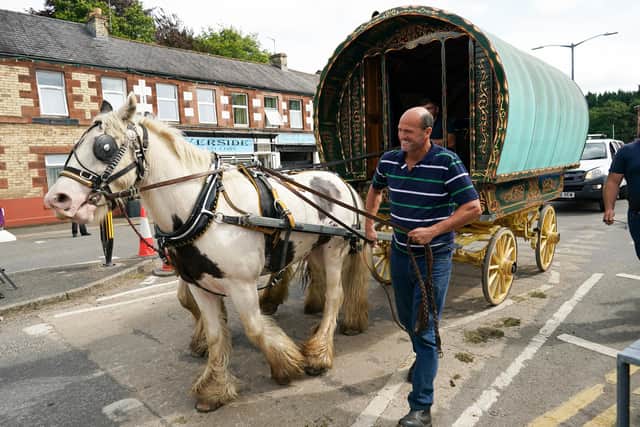 A bow top wagon is led through the centre of town on the first day of the Appleby Horse Fair on August 12, 2021 in Appleby, England. The fair is an annual gathering for Gypsy, Romany and travelling communities. The event has existed under the protection of a charter granted by James II since 1685 and it remains one of the key meeting points for these communities. Photo by Ian Forsyth/Getty Images