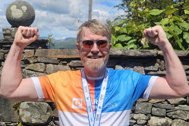 Chris Dewhirst celebrating after swimming Coniston.