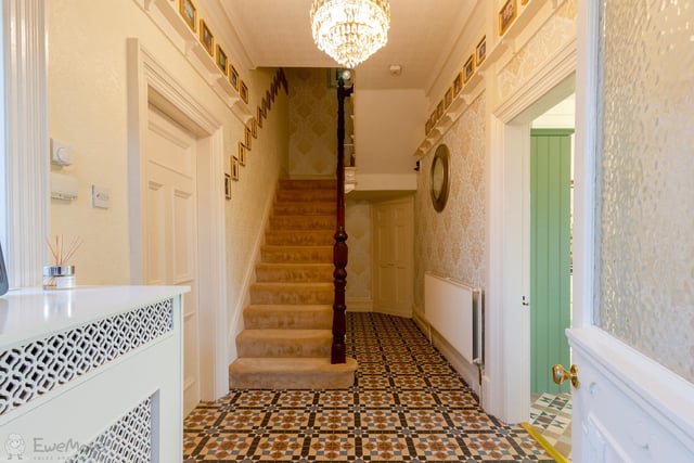 The hallway with staircase has original decorative features.