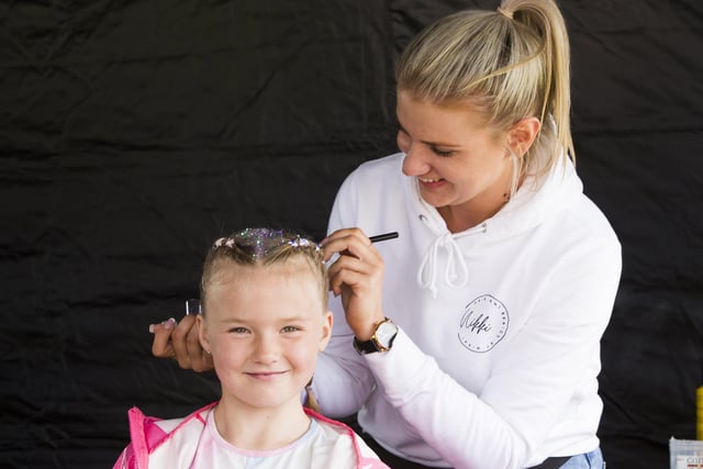 Eleah Booth, 7, has her hair decorated by Nikki Mawman.
