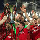 WREXHAM, WALES - APRIL 22: Ben Tozer and Luke Young of Wrexham lift the Vanarama National League trophy as Wrexham win the Vanarama National League and are promoted to the English Football League after victory in the Vanarama National League match between Wrexham and Boreham Wood at Racecourse Ground on April 22, 2023 in Wrexham, Wales. (Photo by Jan Kruger/Getty Images)