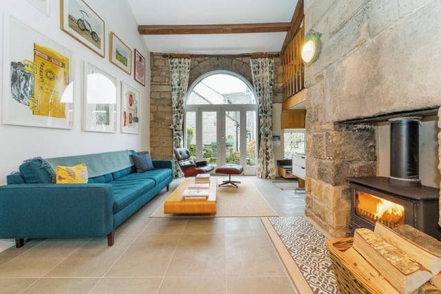 Exposed stone walls and large feature windows add to the property's rustic appeal.