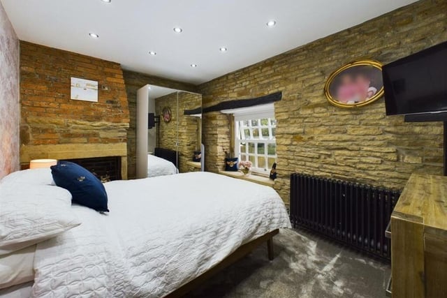 A double bedroom with rustic features and spotlight.