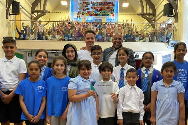 Parkinson Lane's PE Lead Thomas Wood and Headteacher Gugsy Ahmed with students celebrating the award
