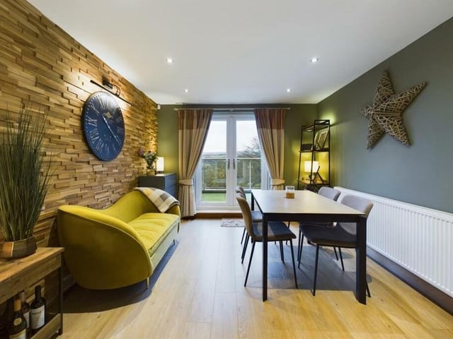 Modern dining space with double doors out to the balcony terrace.