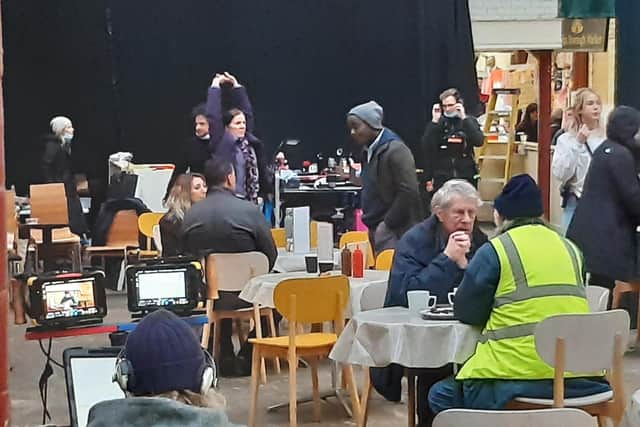 Paterson Joseph - in the beanie hat and coat - filming in Halifax Borough Market