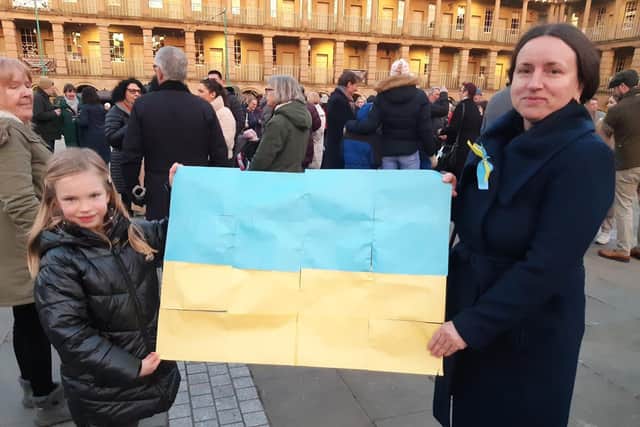 Tetyana Lyuta and her daughter with a Ukrainian flag they made for the Stand with the Ukraine event at The Piece Hall