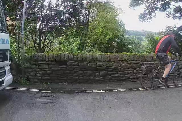 An image captured by residents of a HGV and a cyclist on the narrow route passing their homes at Jumples Crag, Mixenden, Halifax, in August 2021